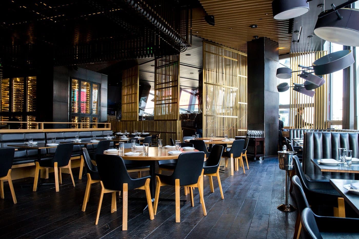 Independent restaurant dining room with warm lighting and set tables, London evening service